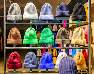 Display of colorful knitted hats in a retail shop showcasing various styles and colors during a winter fashion season