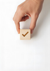 Hand placing the final wooden cube with a checkmark symbol, showing success and accomplishment, minimal clean background, corporate achievement concept.
