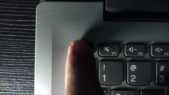 pressing the esc key on a laptop keyboard with one index finger, cinematic lighting