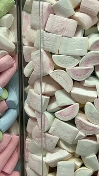 A vibrant display of gummy candies, marshmallows, and sweets at Mercat de la Boqueria, the famous market in Barcelona. The colorful assortment of treats attracts tourists and locals.