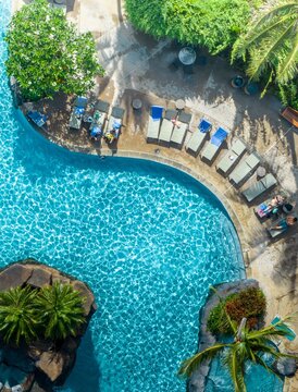 Aerial view of the turquoise pool waters contrasting with the dark rocky outcrops and the green of the palm trees, Poipu, Hawaii, United States.