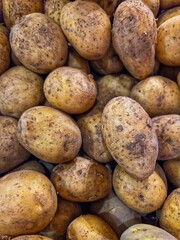 Vertical  close-up of a large pile of fresh raw potatoes.