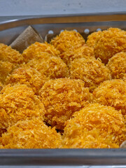 Close-up,  shot of a batch of deep-fried, cheese ball. 