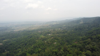 Obraz premium Title Beautiful Mountain Landscape with Green Fields and Blue SkyDescription Scenic view of a mountain range with lush green fields under a bright sky, natural travel and outdoor adventure destinati