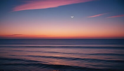 Obraz premium Sunset over the ocean with a crescent moon in the sky