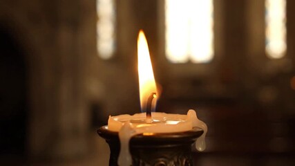 Flame's Mesmerizing Dance Cinematic close-up footage of a flickering candle flame in a serene church setting. - Powered by Adobe