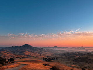 Naklejka premium Golden Hour Over Rolling Hills and Distant Mountains