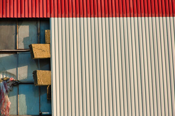 Zbliżenie na elewację budynku przemysłowego, ukazujące falisty pas blachy z metalu pod którą znajduje się ocieplenie z wełny mineralnej. © Pol Badger