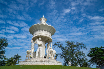 Obraz premium Phuket Thailand.13 August 2025: The sculpture at the Karon Beach roundabout stands beneath a sky filled with small, fluffy clouds, gently diffusing the sunlight and casting a soft light over the scene