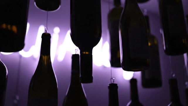 Wine bottle installation with vibrant purple neon light, perfect for bar promotion or elegant event invitation video sequence
