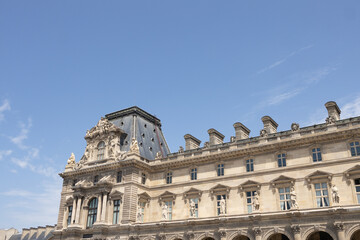 Obraz premium Historic architectural masterpiece featuring ornate details and a striking roof against a clear blue sky, showcasing the grandeur of classical design and cultural heritage