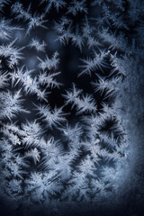 Frosty Window: Detailed close-up of intricate ice crystals forming a delicate, abstract pattern on a cold winter pane.