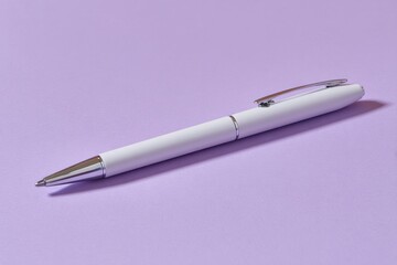 White pen on purple background office supply writing tool