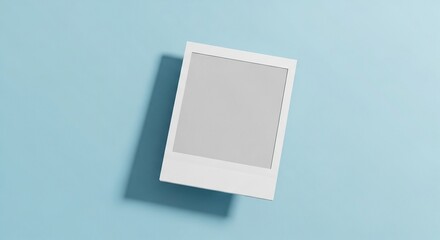 Blank instant photo frame mockup on light blue background with shadow.