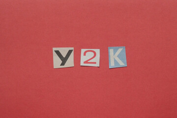 Y2k letters cut from newspaper on red background
