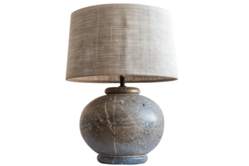 A beautifully crafted stone lamp with a textured fabric shade illuminating a serene interior space with elegance and charm isolated on transparent background