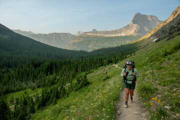 Fototapeta premium Woman Backpacks Up Steep Trail to Ptarmigan Tunnel