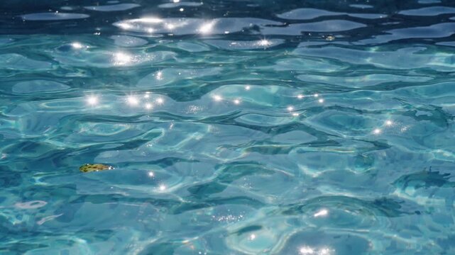 Blue Water surface, abstract background with a sun glittering reflection, slow motion
