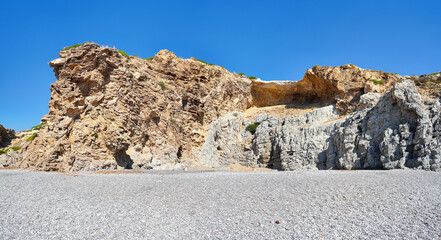 Sun shines to rocky formations near pebbles beach at Traganou on Rhodos