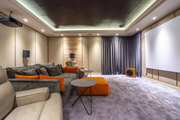 Room features a large screen, comfortable seating, and soft lighting, creating an inviting atmosphere for enjoying films and entertainment