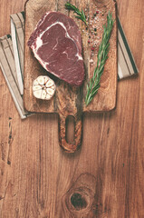 raw steak, beef steak, rib eye steak, on a cutting board, freshly frozen, on the table, top view,