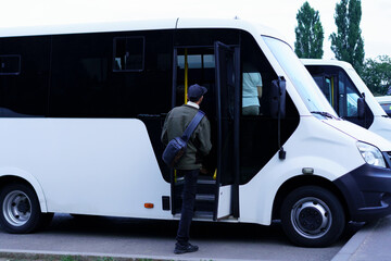 Person boarding a shuttle bus in a parking area on a cloudy day