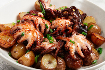 baby grilled octopus with golden baked potatoes and fresh herbs, Maltese cuisine, homemade, no people,