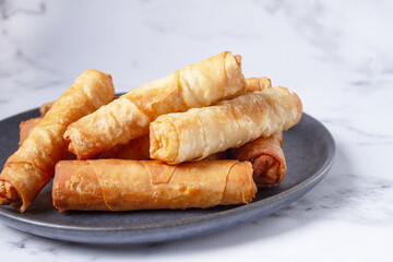 fried spring rolls with cheese, on a plate, with cream sauce, no people,