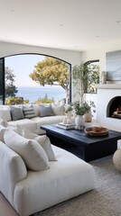A spacious, modern living room showcases a breathtaking ocean view, featuring light neutral tones and a dark coffee table.