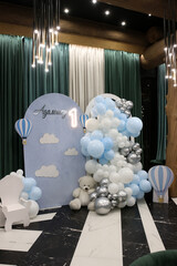 Decoration with blue and white balloons, teddy bear and number 1 for celebrating a first birthday party.