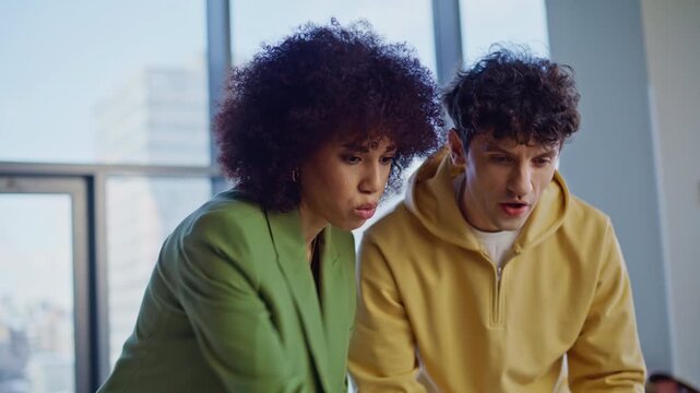 Design office customer complaining on project to designer looking laptop closeup