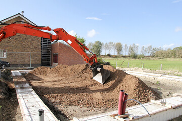 the arm and bucket of a mobile excavator is adjusting ground at a construction site in the countryside 