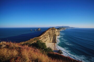 Afternoon view of coastal cliffs with a wide sky and beach background