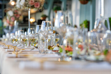 wedding table setting.  close-up of elegant wine glasses on a long banquet table set for a luxury wedding or fine dining event with shallow depth of field