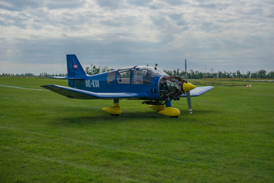 Flugplatzfest, Spitzerberg, Austria, Europe - Sep 27, 2025: blue robin dr400 aircraft with yellow nose and wheel fairings on grass at a small airfield