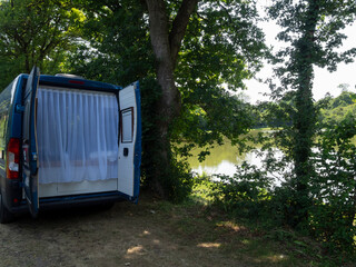 Camioneta azul, con cortina blanca, abierta aparcada al lado del &Euml;tang du vivier de l'avent en Saint Sauveur-le-Vicomte en Normand&iacute;a Francia, viaje en verano 2022
