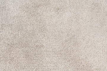 Beige textured backdrop resembling a carpet or towel crafted from wool or synthetic fibers such as polypropylene, nylon, or polyester