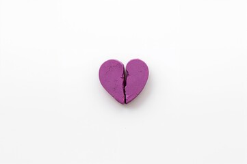 Fototapeta premium Cracked purple heart-shaped candy for Valentine's Day on a white surface