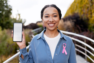 Woman with pink ribbon holding phone for breast cancer awareness