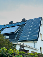 Fototapeta premium Solar panels installed on a modern house roof in a residential area showcasing renewable energy solutions