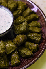 Dolma on a large ceramic plate with cream sauce