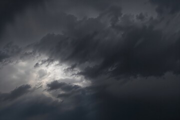 Obraz premium Dark stormy clouds with sun rays breaking through the sky