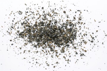 Dark granulated tea against a white backdrop