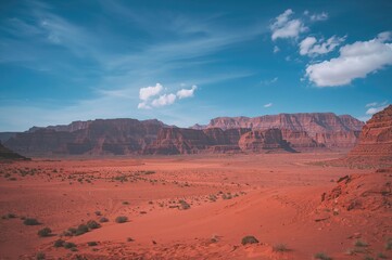 Fototapeta premium Desert landscape featuring sand dunes and rocky mountains under a clear sky, ideal for adventure and travel enthusiasts