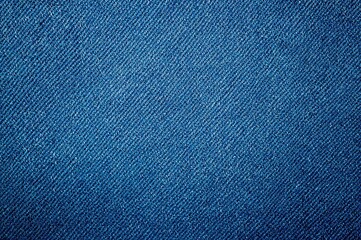 Close-up shot of distressed denim fabric with a blue grunge finish, showcasing diagonal weave texture and canvas material, ideal for upholstery and garment design.