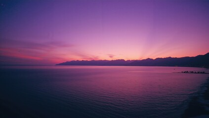 Panoramic ocean vista with hills under a violet twilight sky