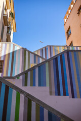 Alicante, Spain – Nov 14, 2021: A public staircase with vibrant, colorful stripes. This unique street art is a famous landmark in the historic old town of the city.