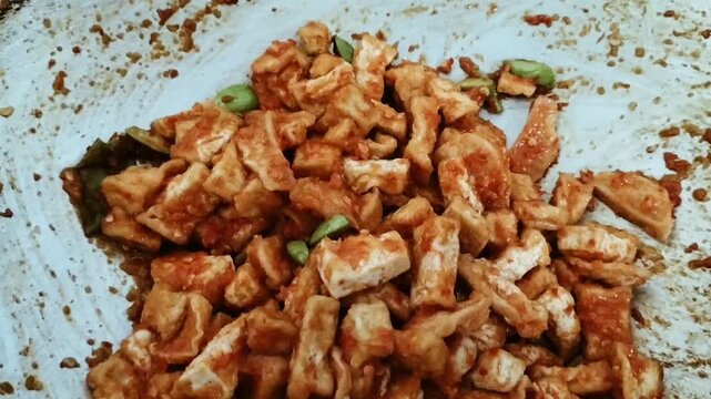Footage. Yellow tofu cooked into spicy Balado-style stir-fried tofu. Indonesian spicy tofu. Balado tahu.
