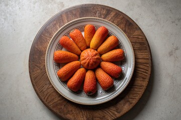 Artocarpus integer fruits displayed on a dish set on a wooden tabletop