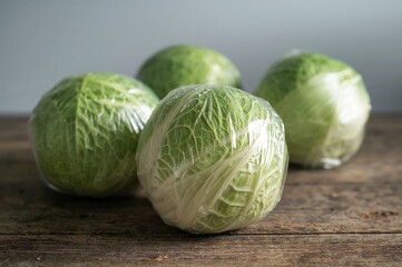 Newly picked cabbages sealed in transparent wrap, prepared for sale.